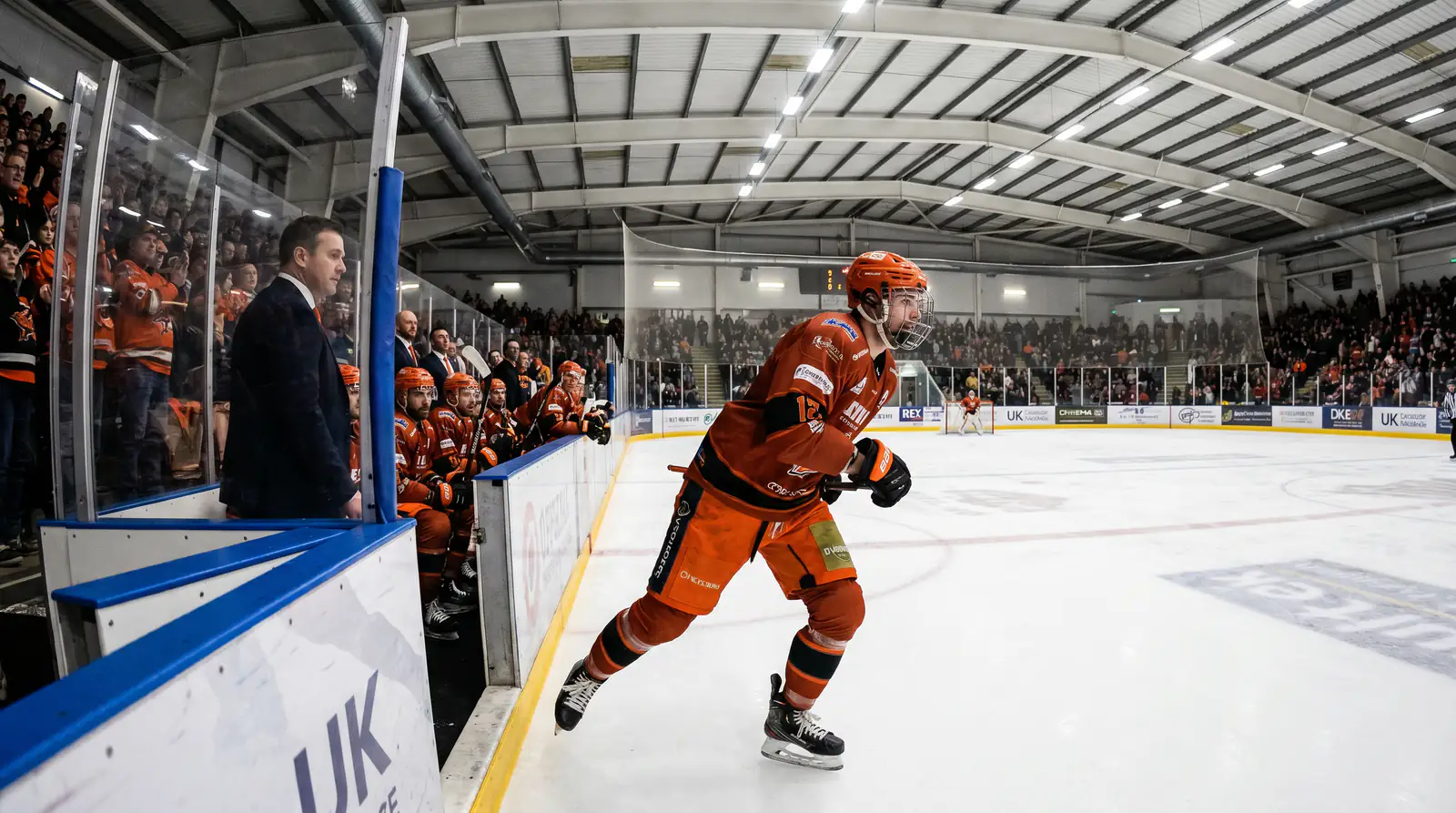 EIHL Sheffield forward in mid-stride during a regular-season match with the coach watching
